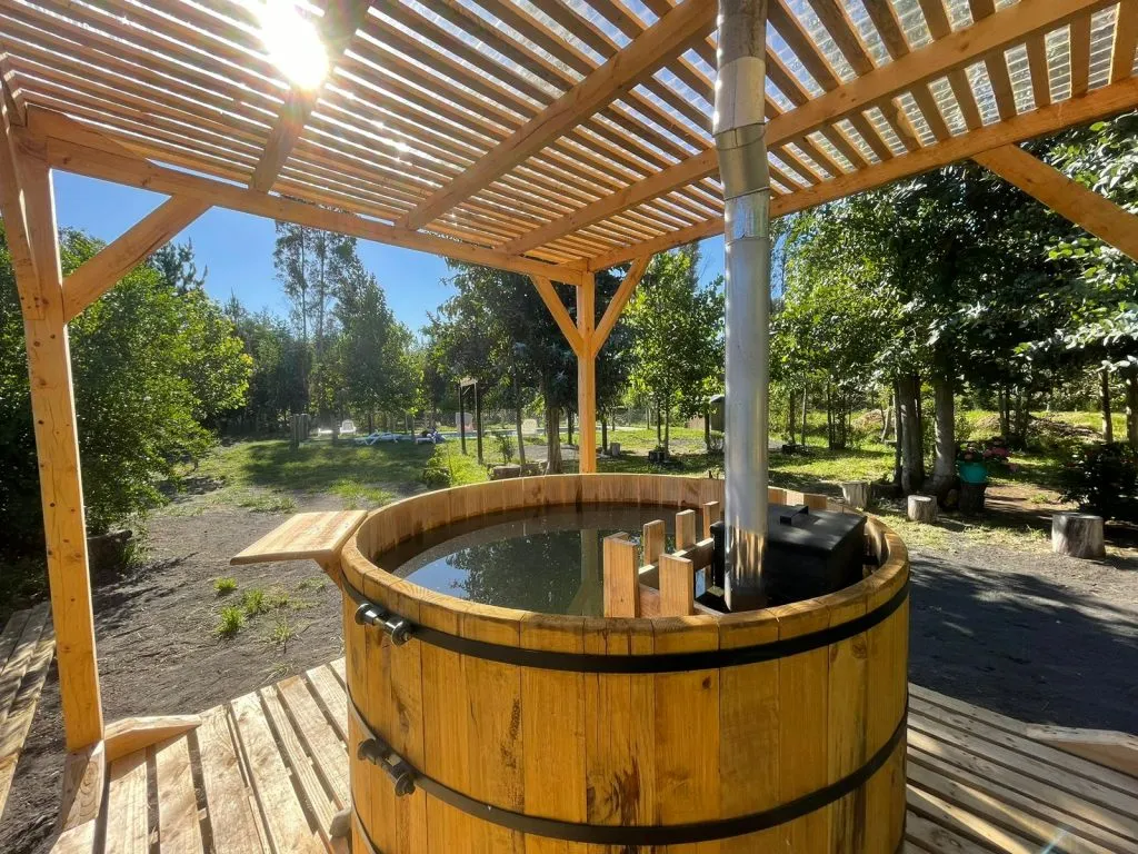 Tinaja de madera artesanal con pérgola y vista al jardín en Aguas Verdes