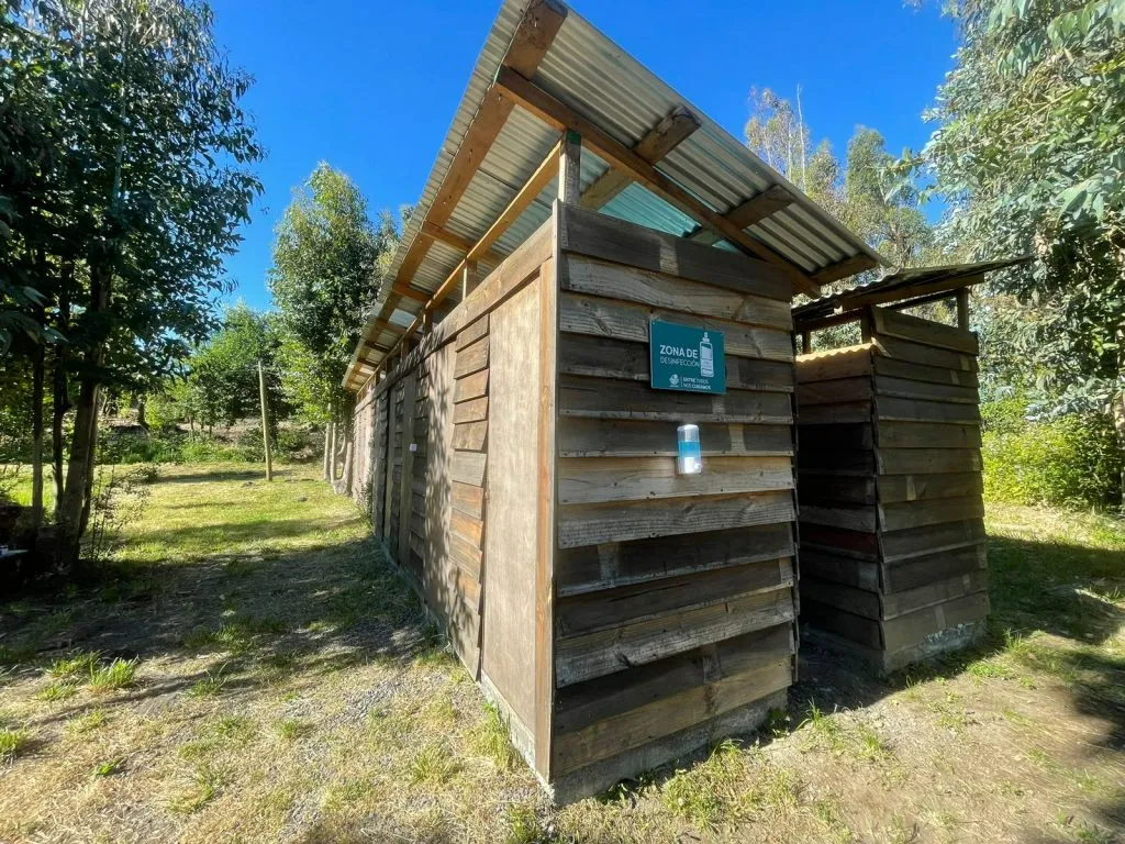 Baños y servicios higiénicos de madera con zona de desinfección en el camping